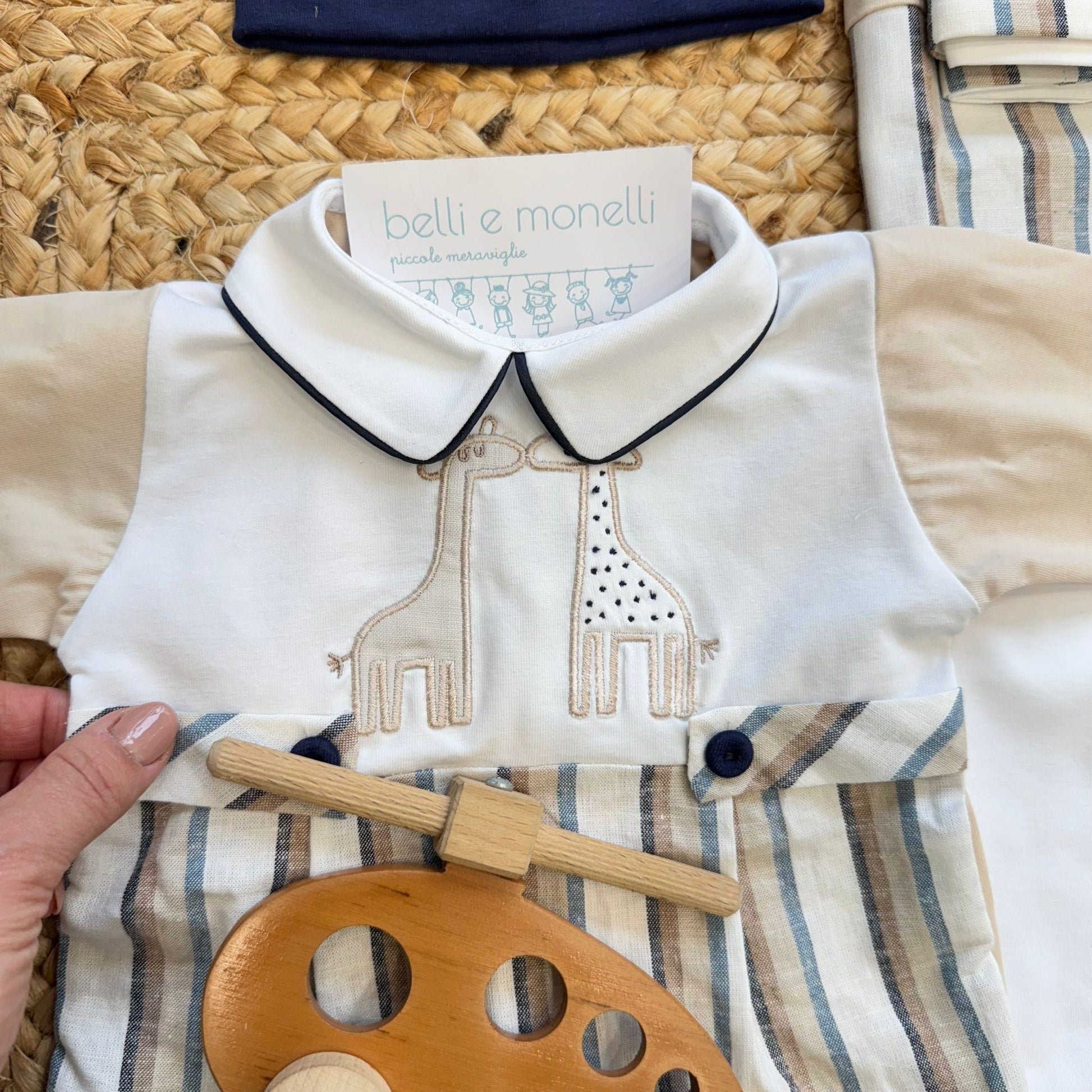 Dettaglio tutina neonato con colletto bianco e ricamo giraffe