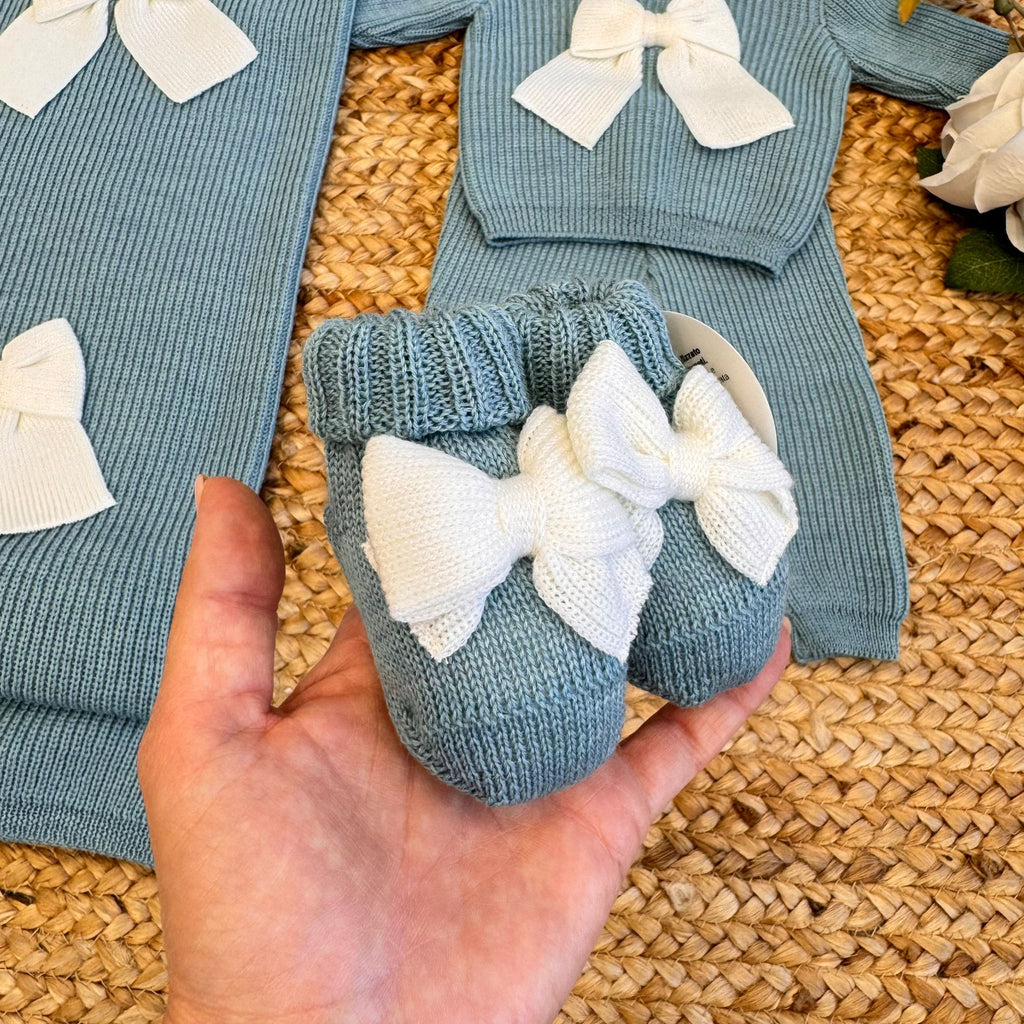 Primo piano tutina neonato con fiocco panna e colletto bianco