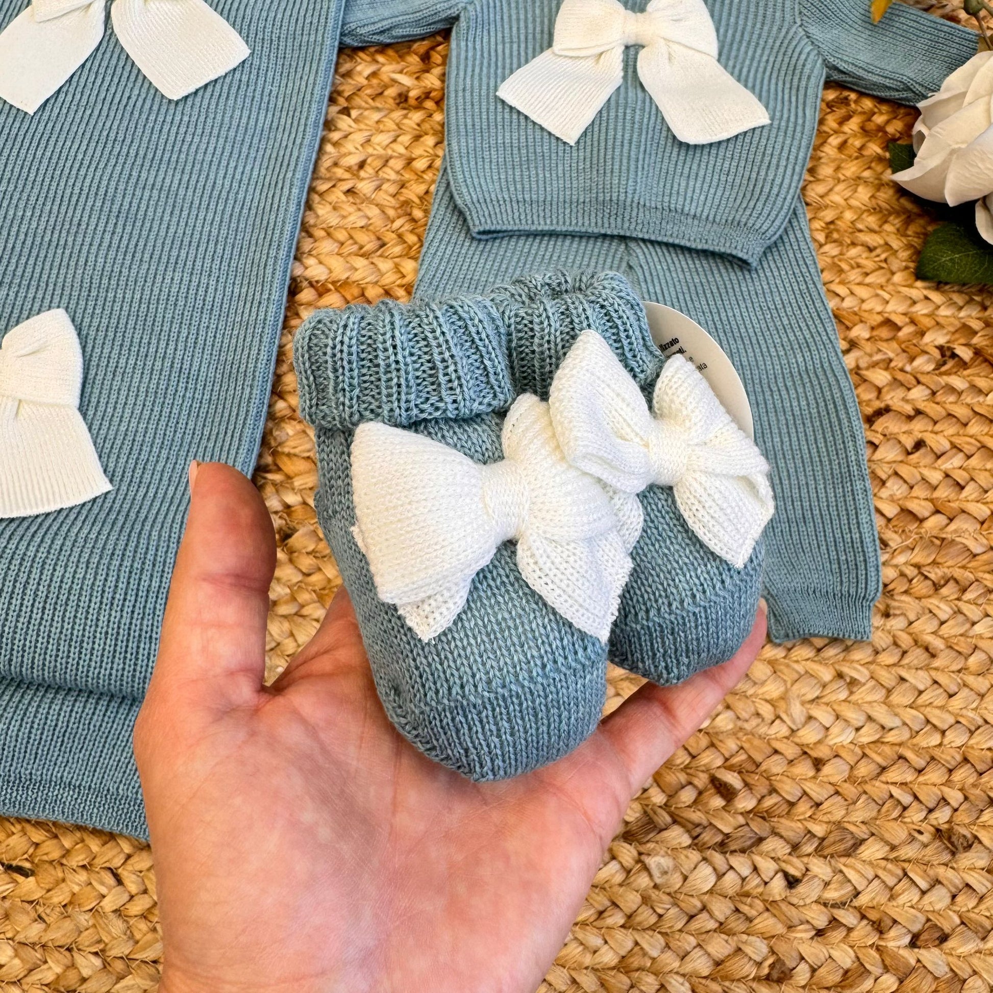 Primo piano tutina neonato con fiocco panna e colletto bianco