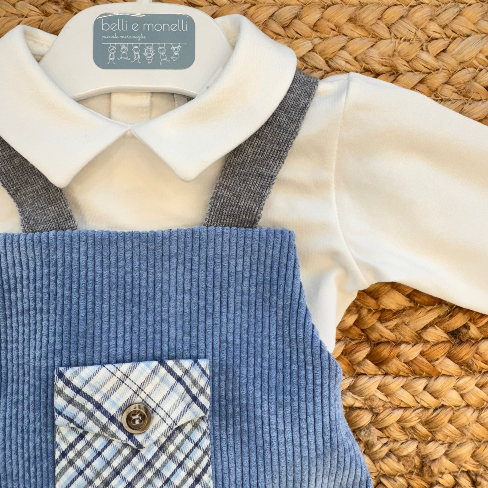 dettaglio colletto camicia bianca e bretelle su completo velluto neonato