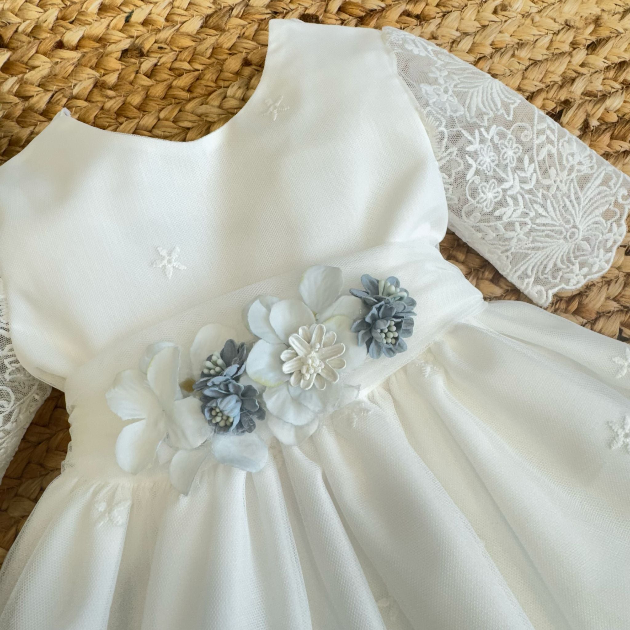 Corpetto con micro-ricami e fiori applicati su abito battesimo bambina.