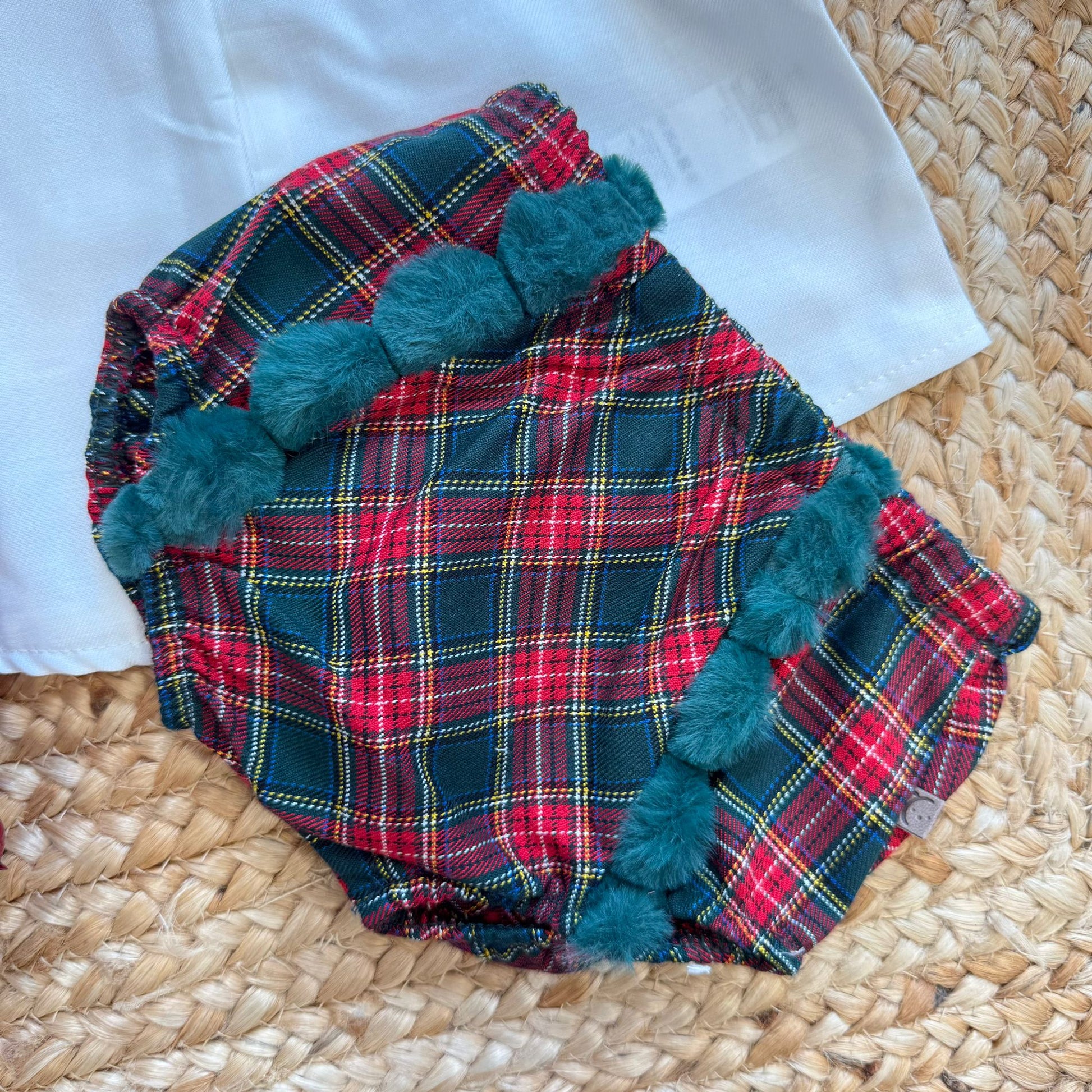 dettaglio culotte scozzese con pompon verdi