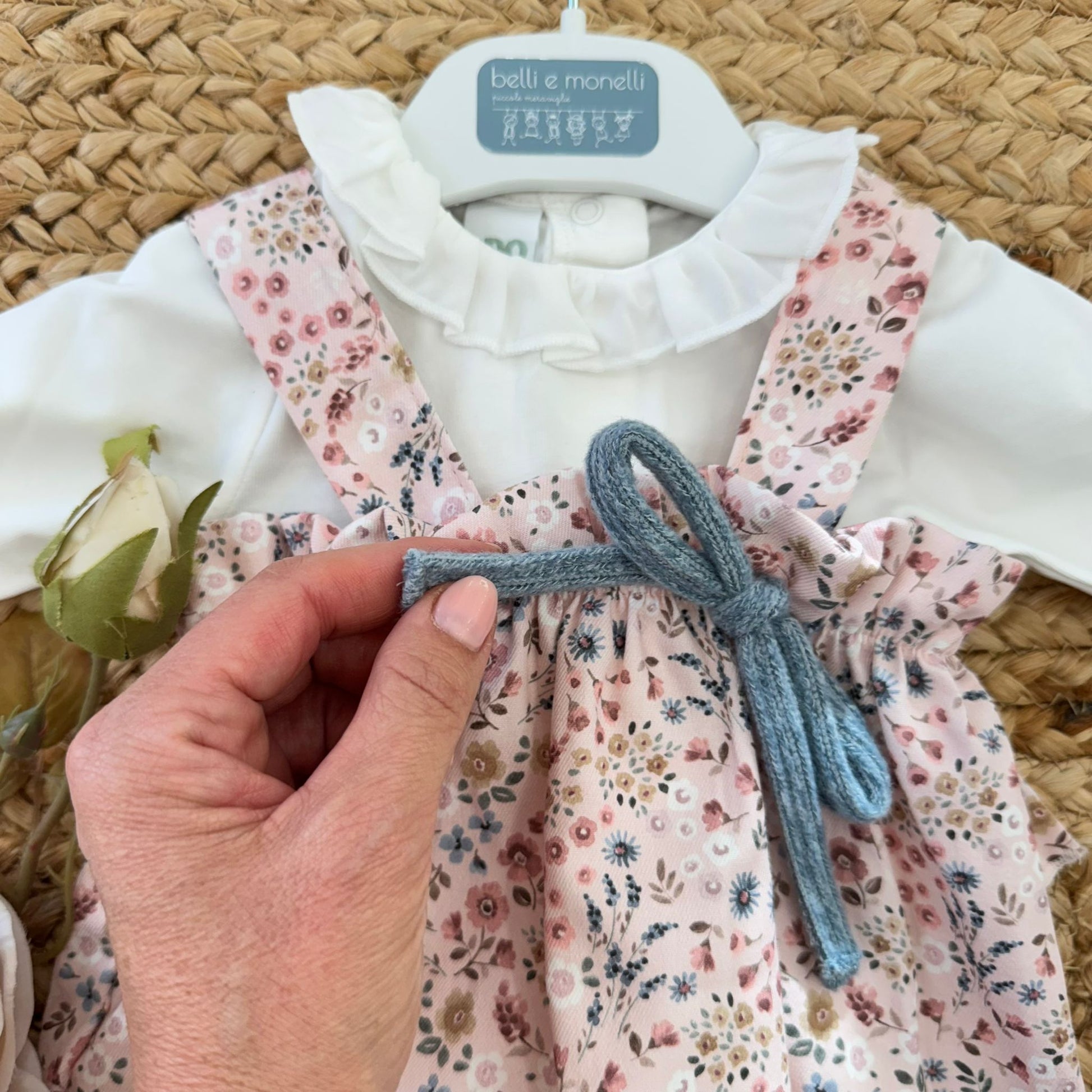 dettaglio fiocco azzurro maglia su salopette rosa