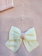 dettaglio fiocco panna su copertina rosa in lana