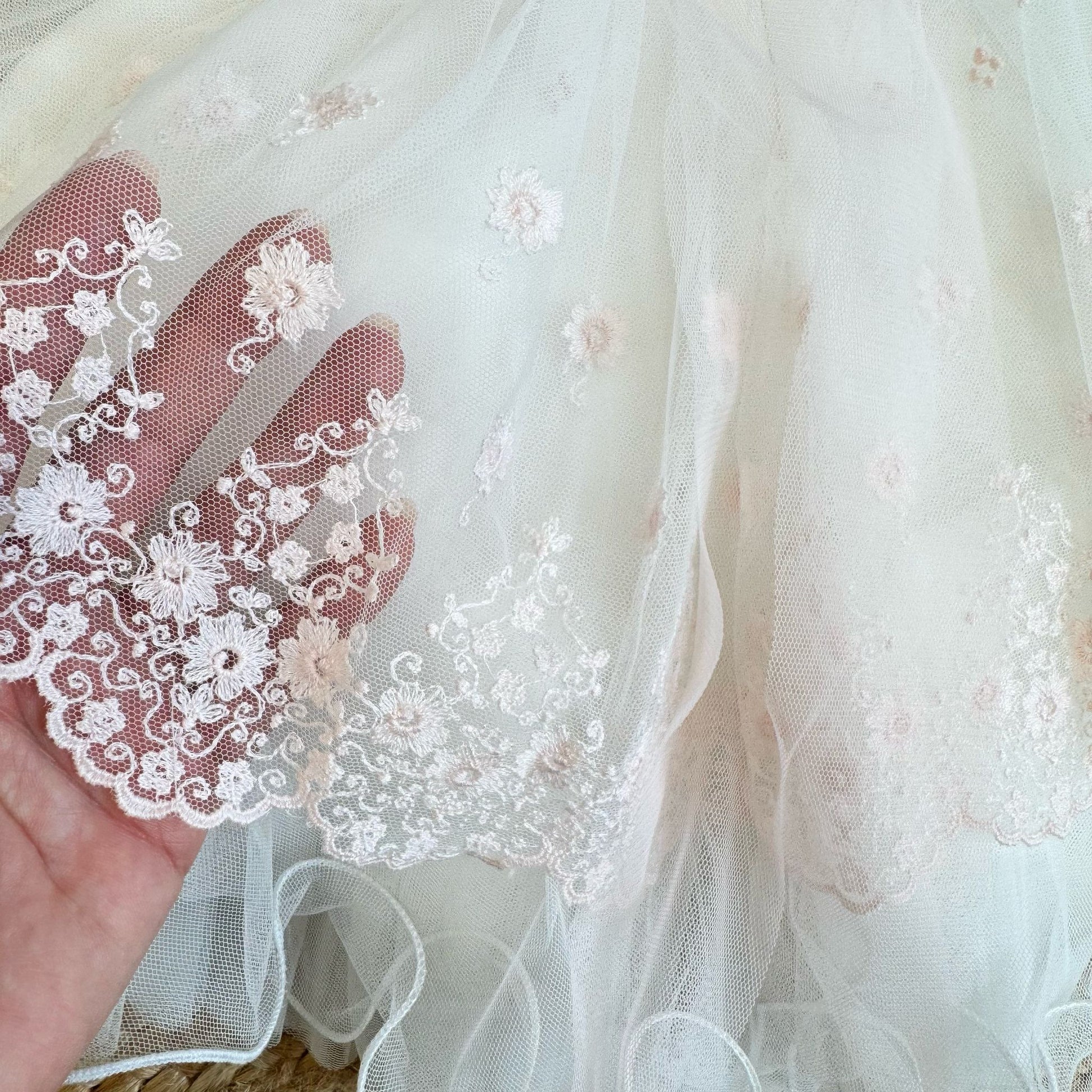 Dettaglio dei ricami floreali rosa sul tulle dell’abito Mimilù