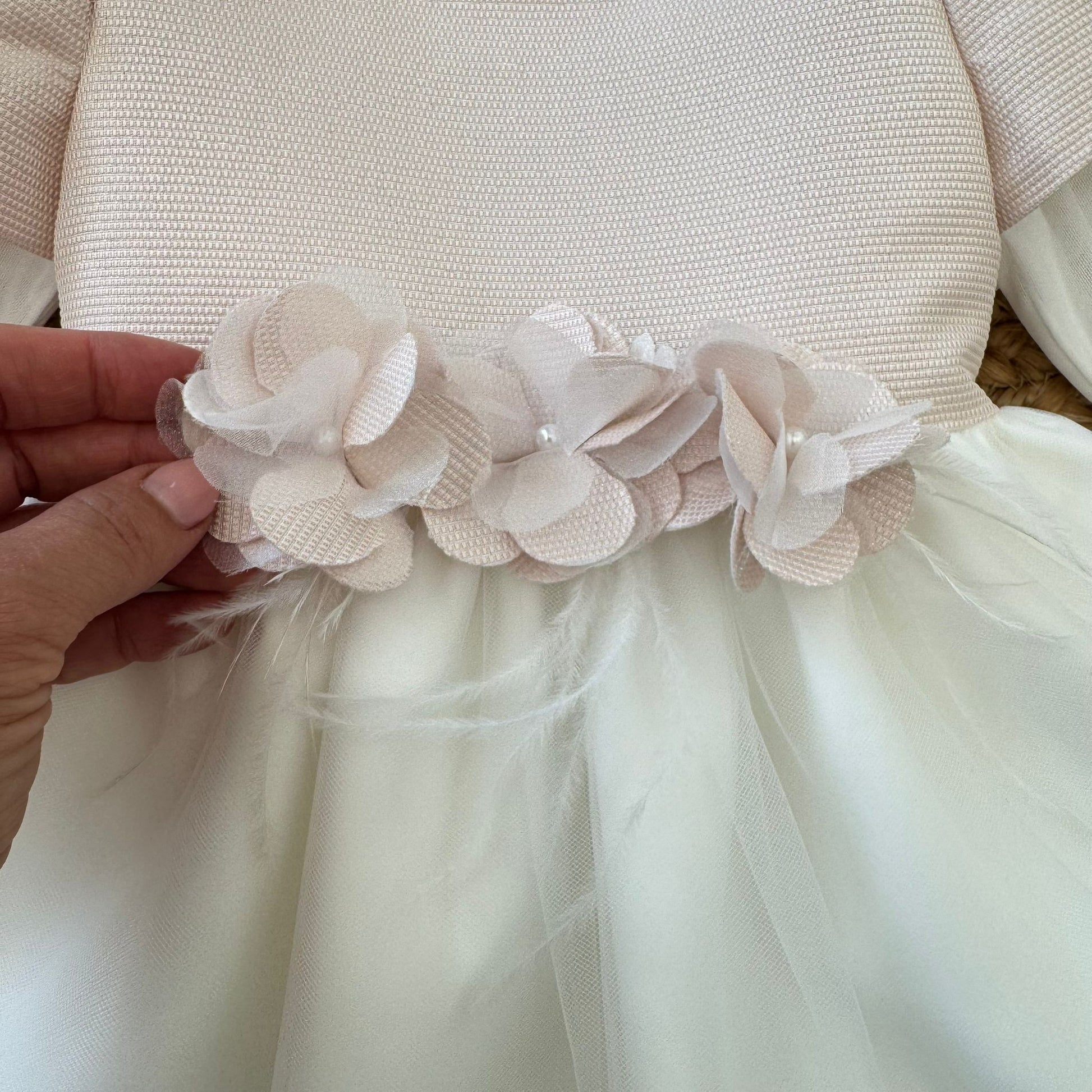 dettaglio fiori in tessuto e piume sul punto vita