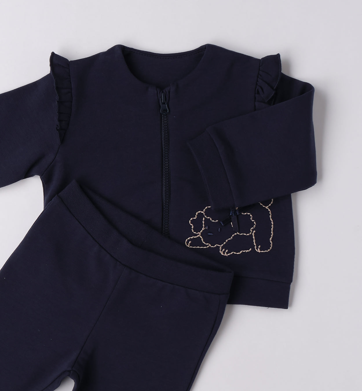 dettaglio giacca blu con zip e volant tutina neonata