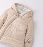 dettaglio giubbotto imbottito beige con ricamo orsetto