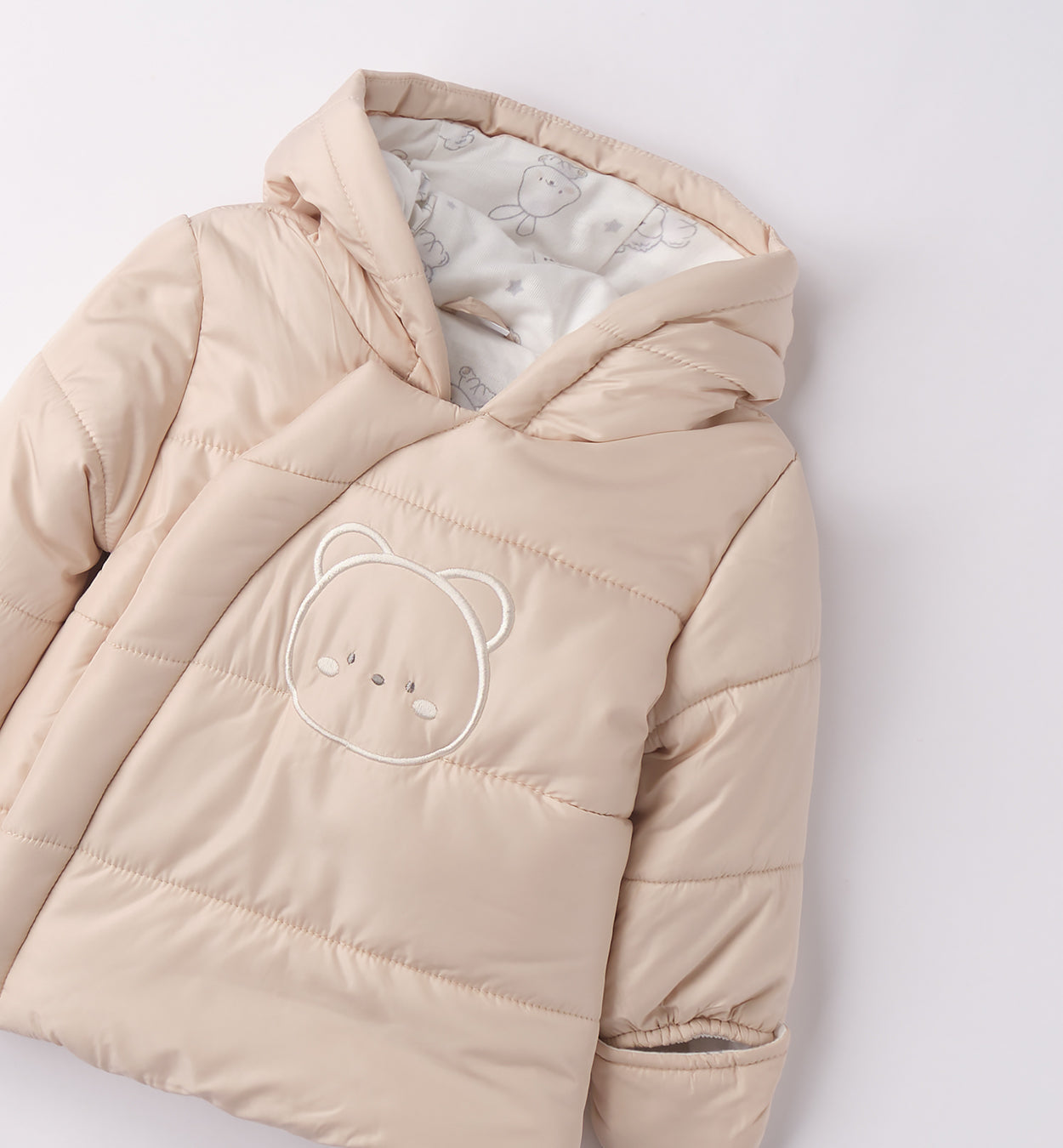 dettaglio giubbotto imbottito beige con ricamo orsetto