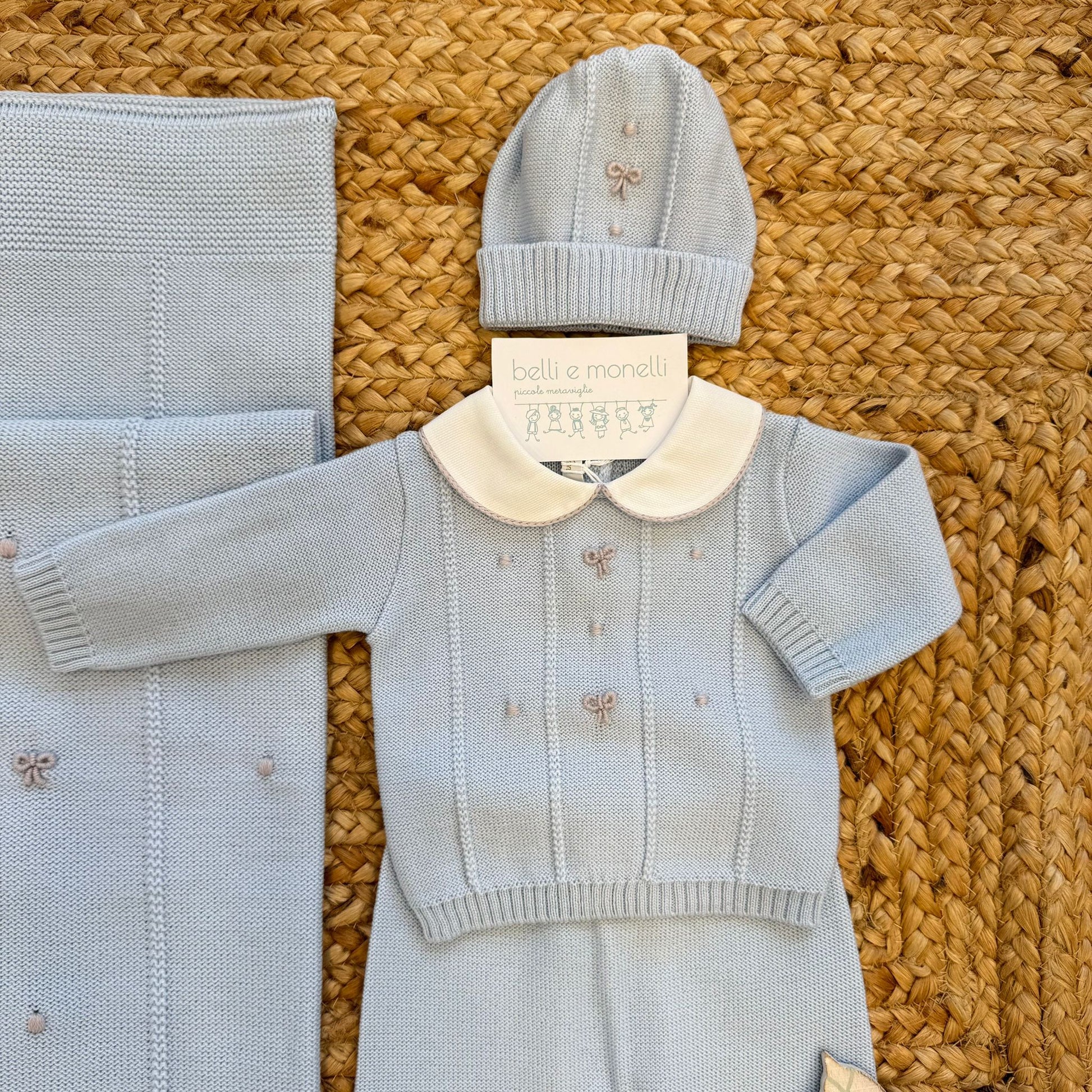dettaglio maglia corredino nascita azzurro in 100% lana con ricami fiocchi