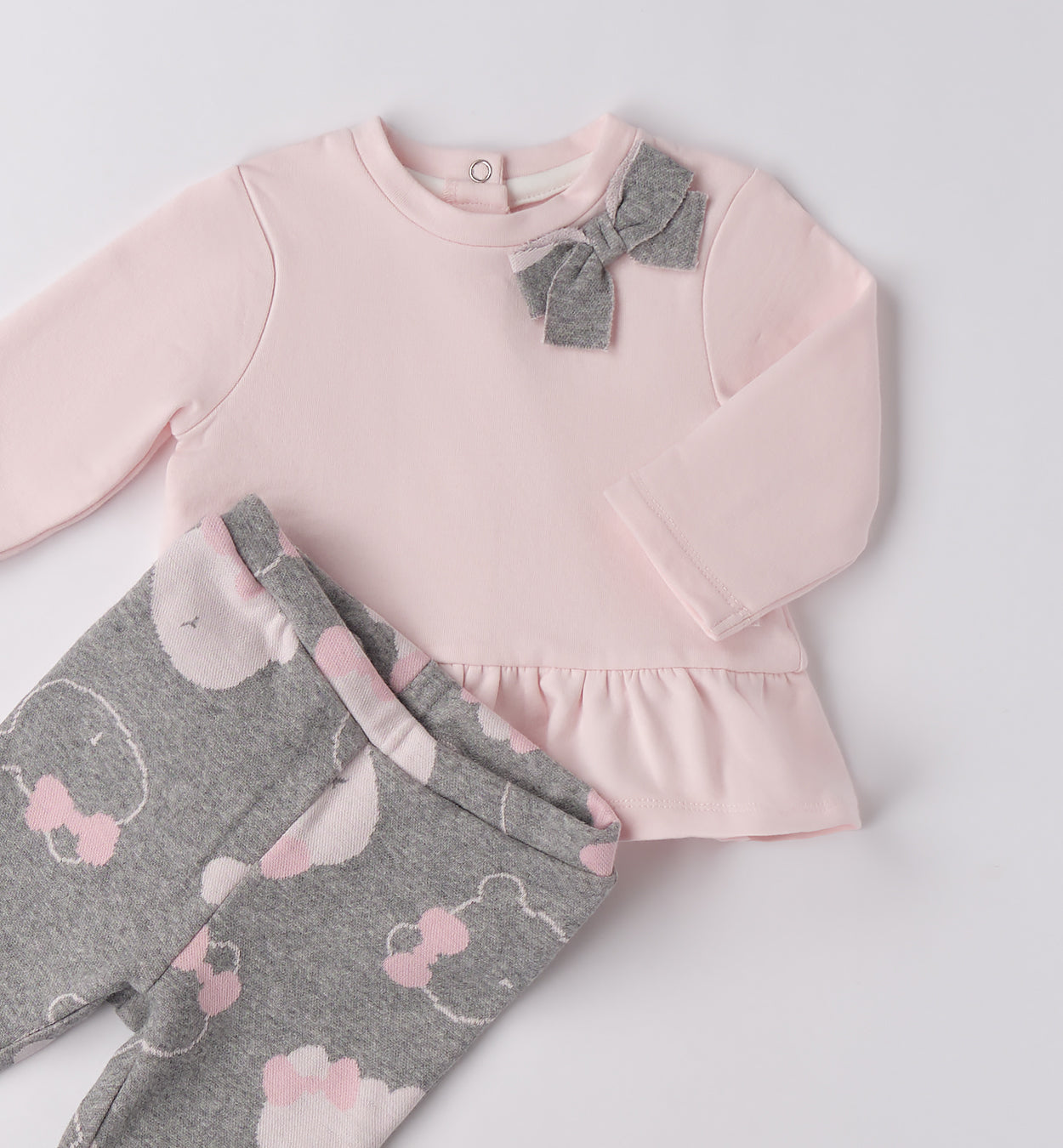 dettaglio maglia rosa neonata con fiocco e volant abbinata a pantalone fantasia orsetti