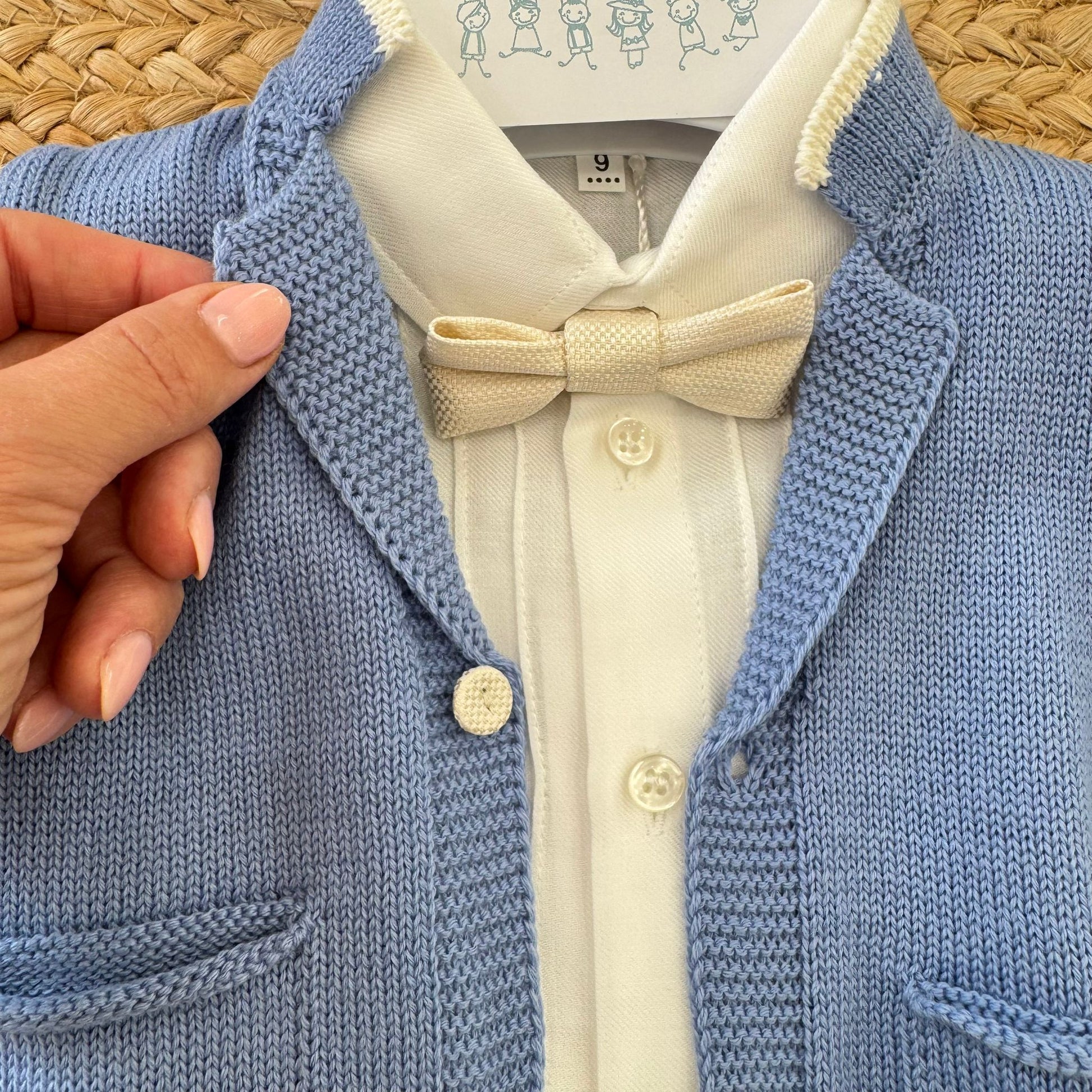 dettaglio papillon e cardigan lavorato a maglia