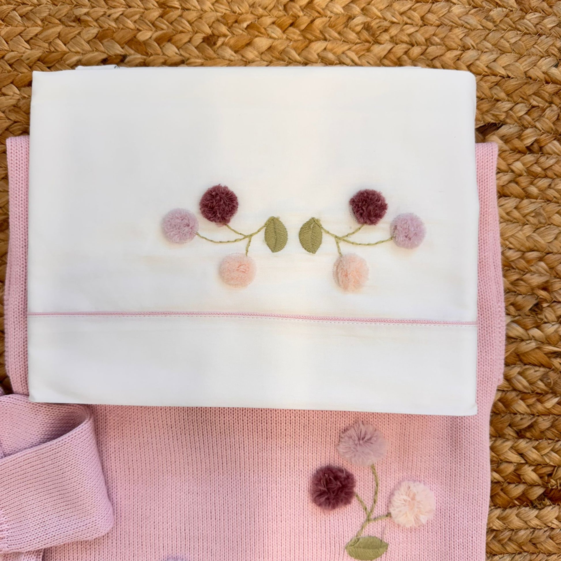dettaglio ricamo fiori su maglia e copertina neonata