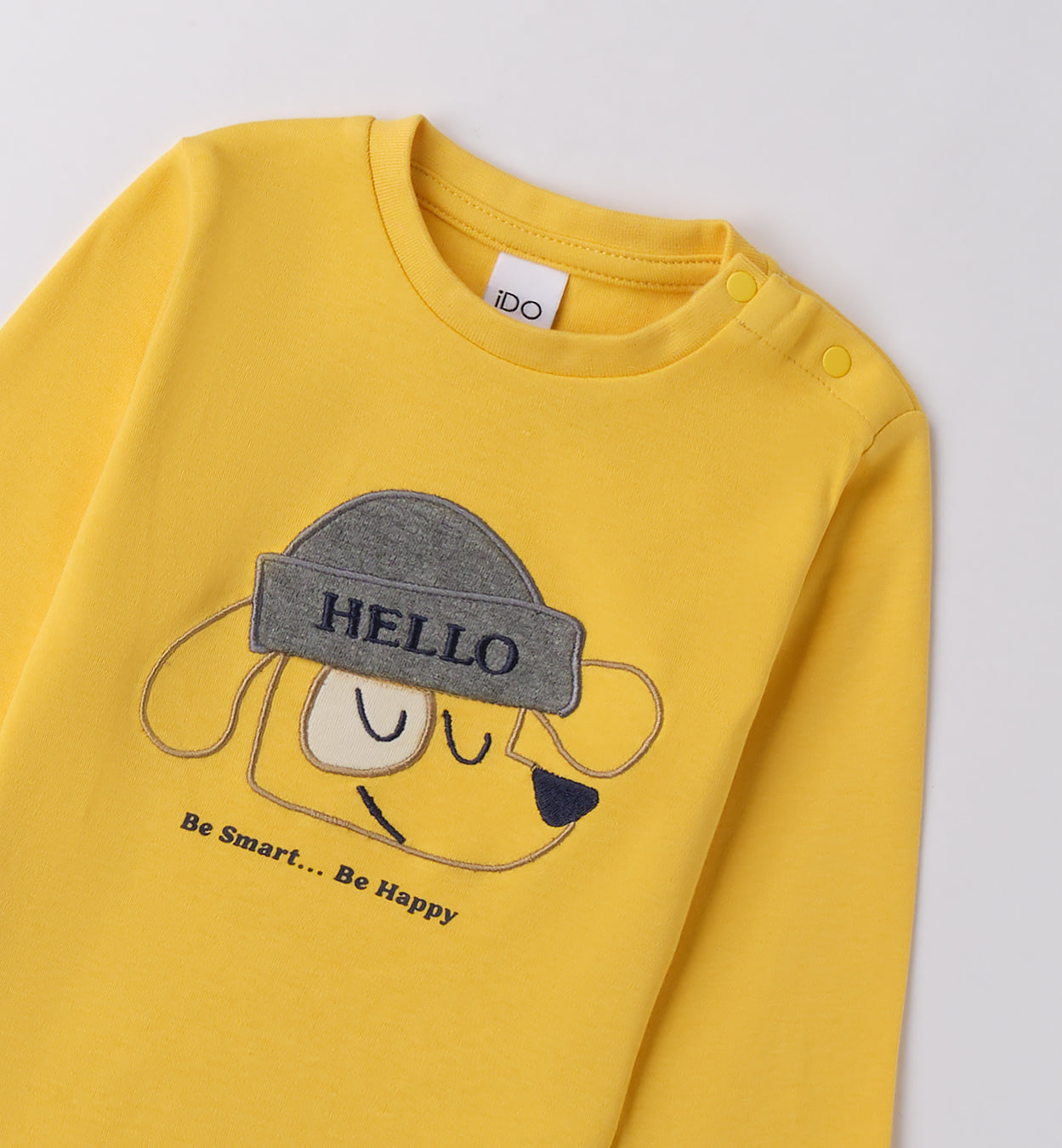 dettaglio stampa cagnolino con berretto grigio su maglia gialla bambino