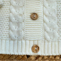 dettaglio treccia e bottone in legno cardigan baby