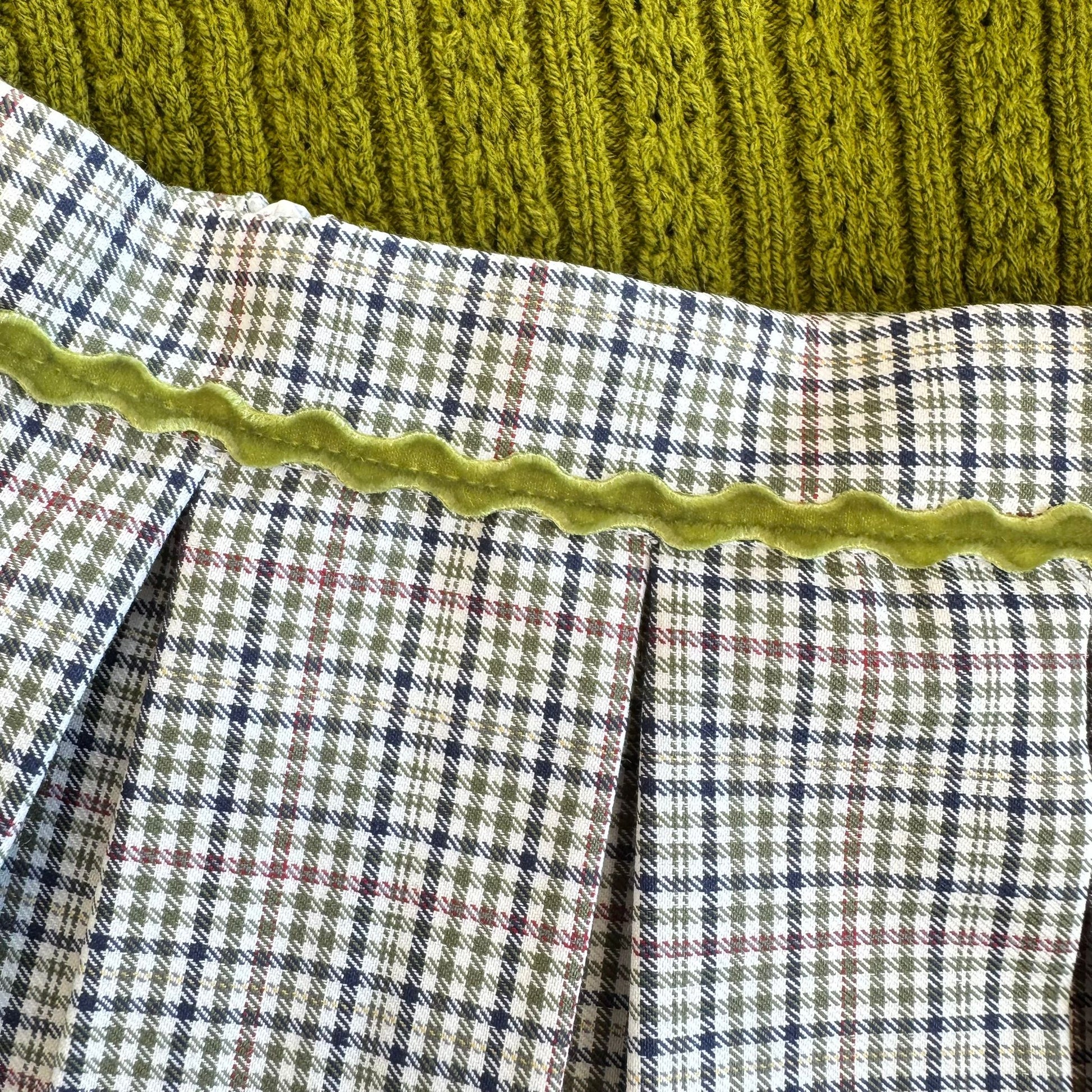 dettaglio velluto verde sulla gonna a pieghe