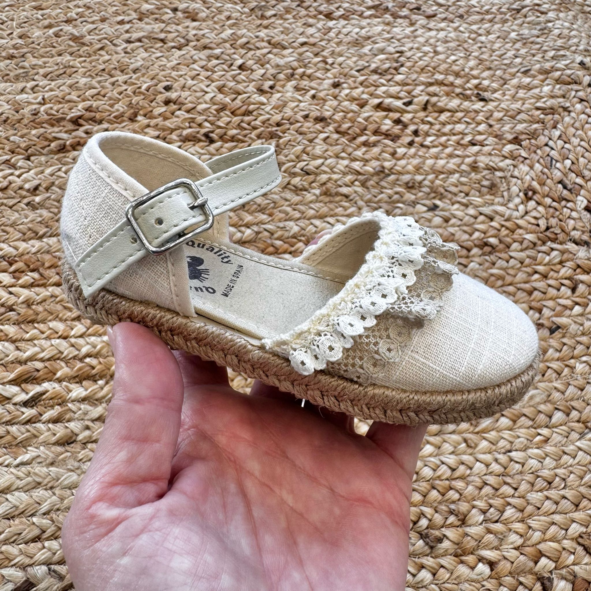 Espadrillas eleganti in tessuto avorio con dettagli in pizzo e suola in juta intrecciata, ideali per look raffinati.