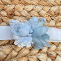 Dettaglio fascia cerimonia bimba con applicazione floreale azzurro polvere