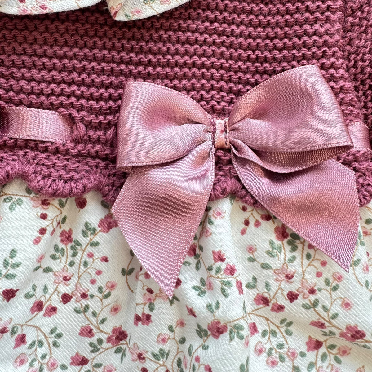 Pagliaccetto bimba in cotone vinaccio con fantasia floreale, colletto volant e fiocco rosa
