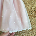 Fiocco in tulle panna sul retro dell’abito battesimo

