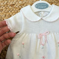 Fiocco rosa e tulipani ricamati su abito neonata