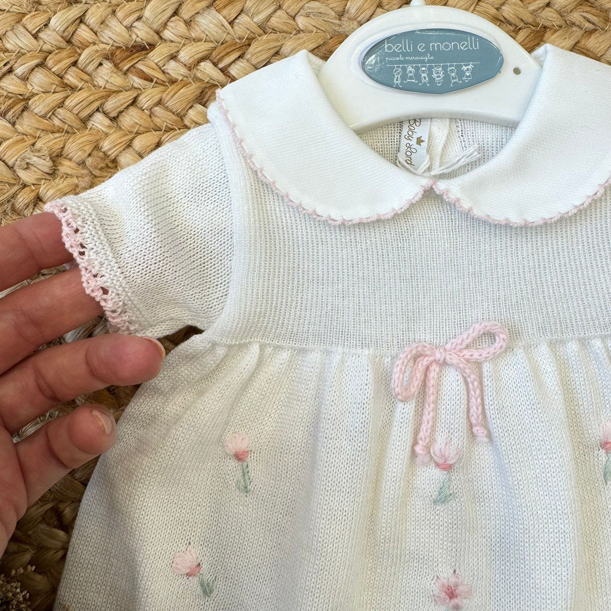 Fiocco rosa e tulipani ricamati su abito neonata