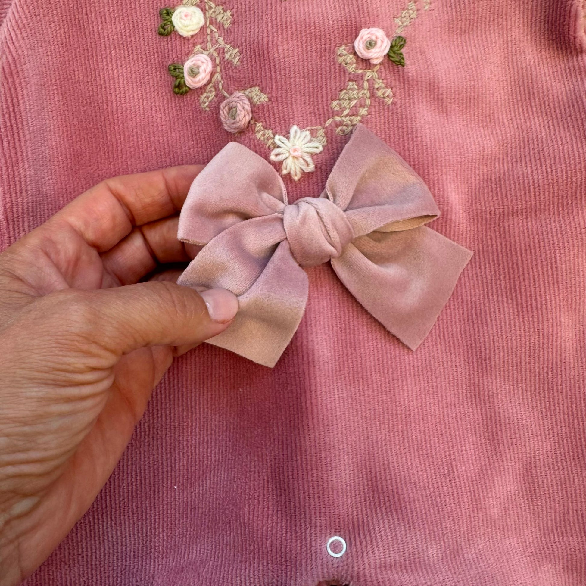 Tutina neonata in ciniglia rosa con ricamo floreale e fiocco elegante