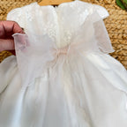 FIORITURA IN ORGANZA E PIZZO SULLA CINTURA DI UN ABITO DA BATTESIMO BIMBA