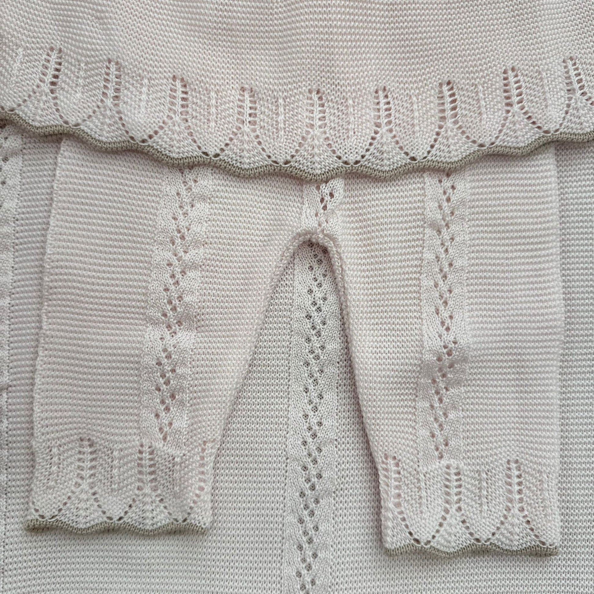 Dettaglio lavorazione traforata ghettina neonata rosa cipria