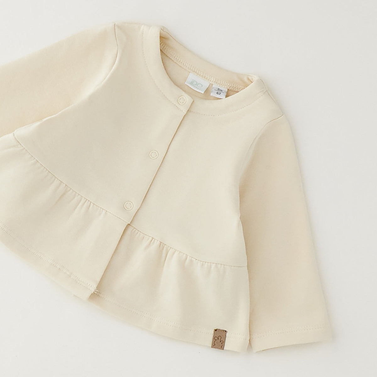 Giacca bimba in caldo cotone color panna con balza e chiusura frontale