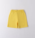 T-shirt bianca con stampa tropicale e pantaloncini gialli per bambino, abbigliamento estivo vivace.