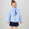 Bambina con giubbotto celeste imbottito e sciarpa coordinata con maxi fiocco