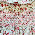 Abito bimba in cotone floreale rosa con lavorazione smock e colletto volant