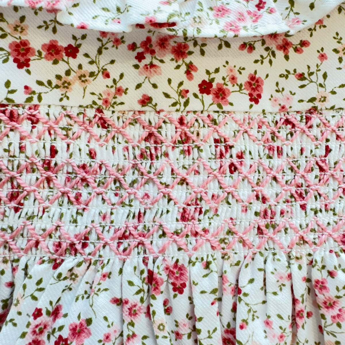 Abito bimba in cotone floreale rosa con lavorazione smock e colletto volant