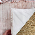 Dettaglio lenzuola in cotone con balza rosa plissé coordinata