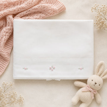 Set lenzuola culla e carrozzina in cotone colore latte con federa ricamata a fiori rosa per neonata.