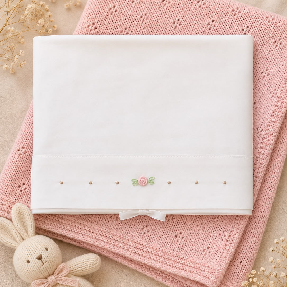 Set lenzuola culla e carrozzina in cotone colore latte con rosellina ricamata rosa e dettagli ricamati per neonata.