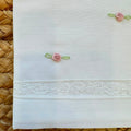 Lenzuola neonata in batista bianca con piccoli fiori ricamati rosa