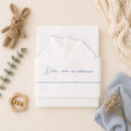 Set lenzuola neonato unisex in cotone bianco con ricamo azzurro Dolce come un abbraccio, composto da lenzuolo sopra, sotto e federa.