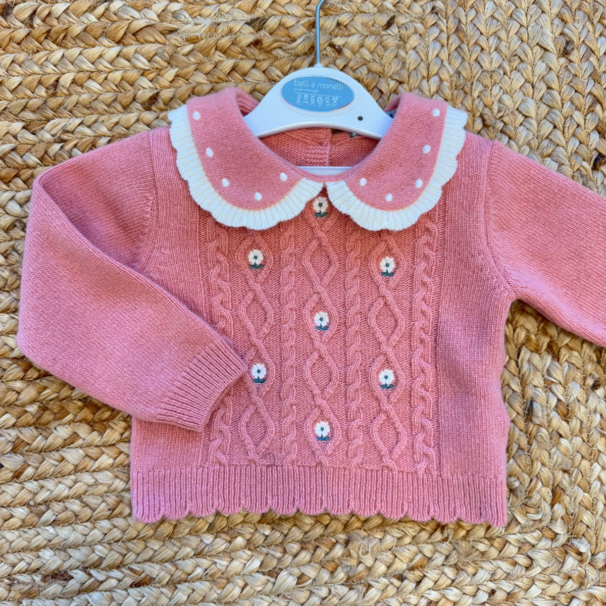 Completo bimba con maglioncino rosa a trecce e pantaloncini panna a coste con ricami floreali.