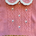 Completo bimba con maglioncino rosa a trecce e pantaloncini panna a coste con ricami floreali.