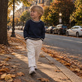 Bambino con maglione panna e pantalone marrone, outfit casual elegante