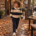 Bambino con maglione verde e jeans, look bambino per l'autunno