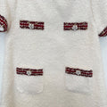 Dettaglio abito elegante bambina panna bouclé con passamaneria bordeaux e decorazioni di perline