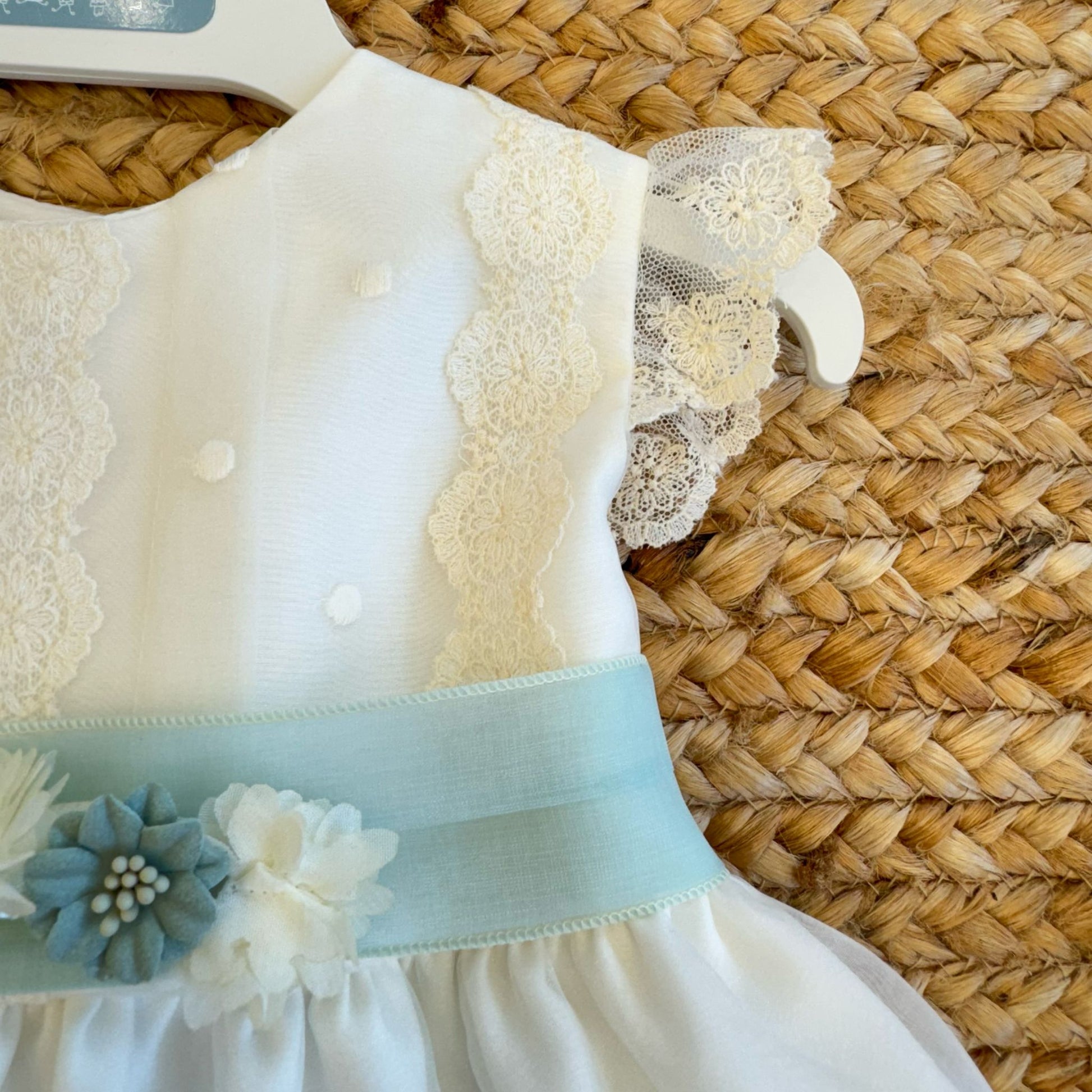 Manichina in pizzo smerlato su vestito cerimonia per neonata