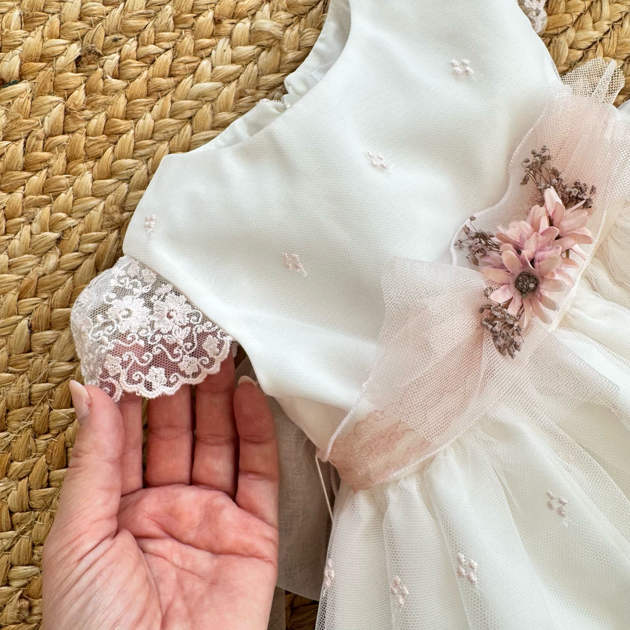 Maniche in pizzo dell’abito battesimo Mimilù, eleganza raffinata.