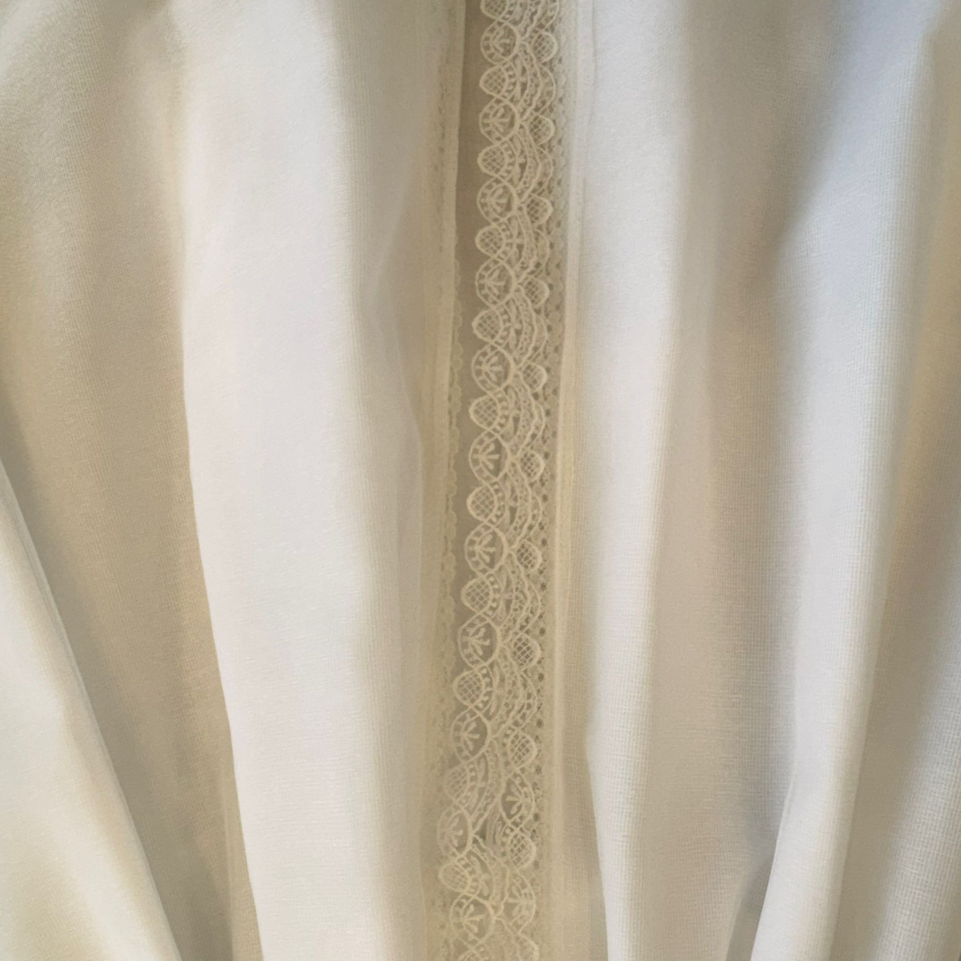 Fascia di pizzo decorativo sul retro dell’abito da Battesimo per neonata