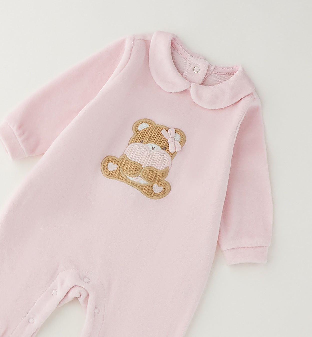 Tutina neonata in ciniglia rosa con orsetto e cuore indossata da neonata