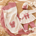 Corredino nascita neonata in pura lana con fiocco rosa, composto da copertina, completo due pezzi, cappellino e scarpine coordinate.