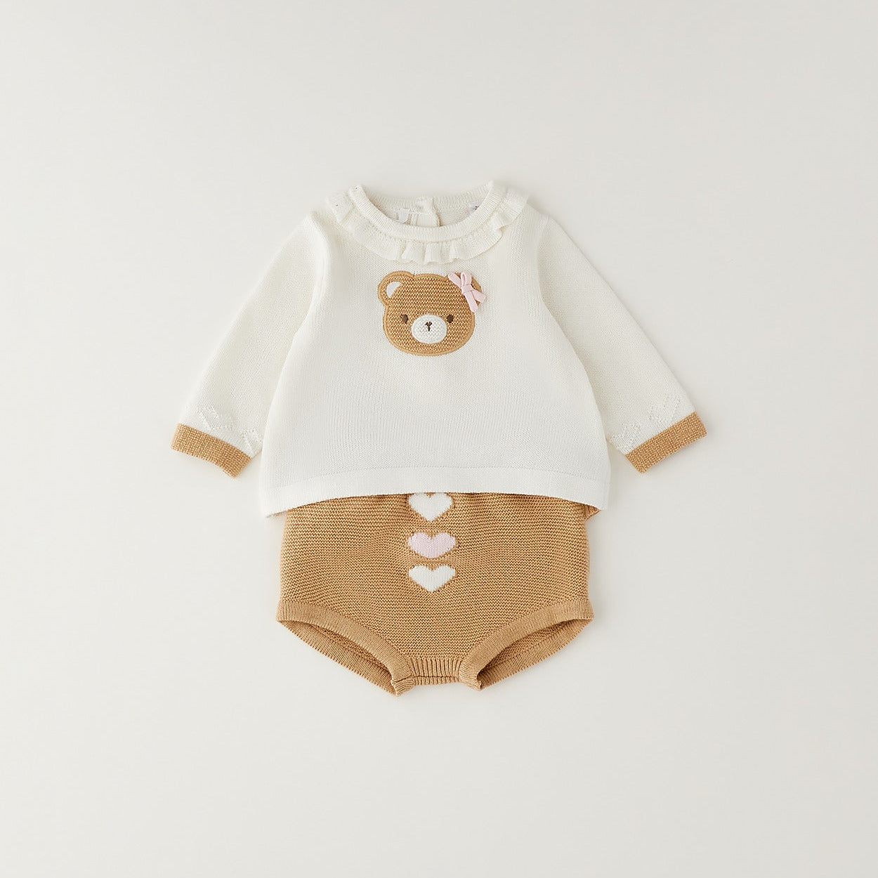 Dettaglio completo neonata cotone e lana con orsetto, fiocco rosa e culotte con cuori